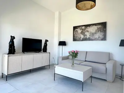 a living room with a couch and a tv at Panoramic Sea View Appartment Blue Pearl in Nice