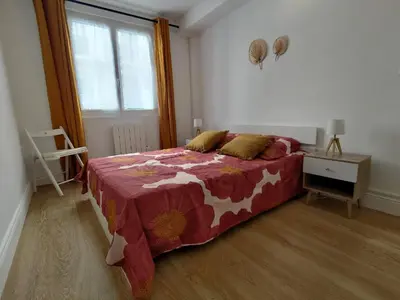 a bedroom with a bed with a red blanket and a window at Appartement Nice Libération in Nice