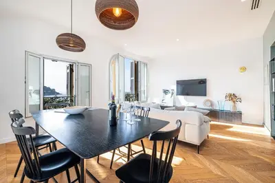 a living room with a table and chairs and a couch at FEEL HOME - VISTA Di PORTU in Nice