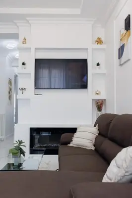 a living room with a couch and a television on a wall at Appartement 3 PIECES NICE Promenade in Nice