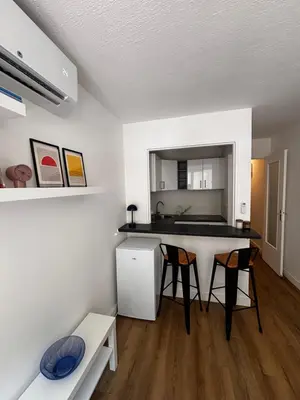 a kitchen with a counter and chairs in a room at Nice appartement for 2 adults with air-conditioning in Nice