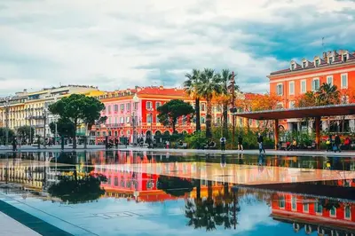 a city with a reflection of buildings in the water at New Central Stylish 2 min from the beach Apartment in Nice