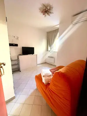 a bedroom with an orange bed and a television at Apartment Massena - super central in Nice
