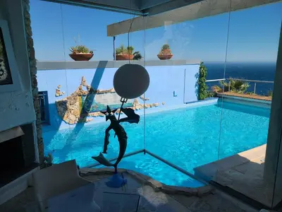 a statue of a person in front of a swimming pool at Eze sur mer - vue Saint Jean Cap Ferrat in Èze