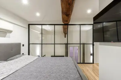 a bedroom with a bed and glass walls at Cocon au cœur du Vieux Nice in Nice