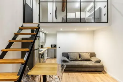 a small living room with a couch and a staircase at Cocon au cœur du Vieux Nice in Nice