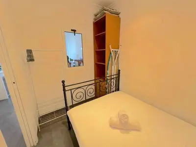 a small bedroom with a bed in a room at Charmant 2 pièces 600m plage 1km de la gare in Nice