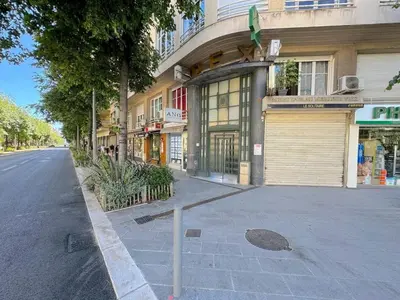 a kitchen with a table and two chairs and a refrigerator at Charmant 2 pièces 600m plage 1km de la gare in Nice