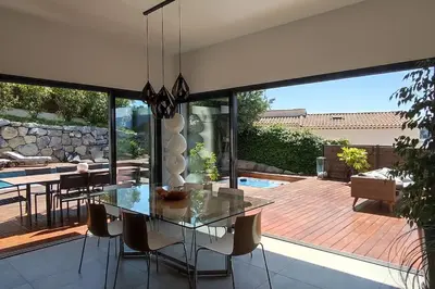 a dining room with a glass table and chairs at VILLA MODERNE PISCINE JACUZZi in Nice