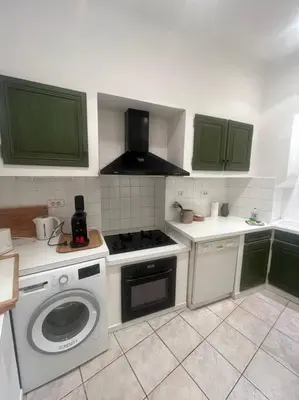 a kitchen with a stove and a washing machine at Centrale - Grand T2 Bis proche de la mer in Nice