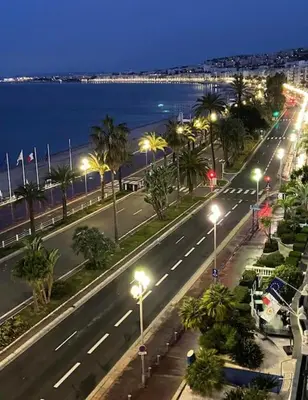 a city street with street lights and the ocean at night at CENTRE VILLE - SUPERBE APPARTEMENT CLIMATISE - COSY-Wifi - in Nice