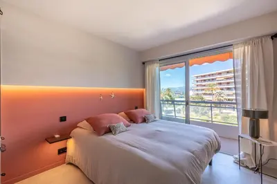 a bedroom with a large bed and a large window at Les Belles Terres - Résidence avec piscine vue mer in Nice