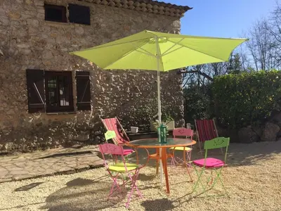 a table and four chairs with a green umbrella at Maison de caractère in Saint-Jeannet
