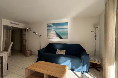 a living room with a blue couch and a table at Nice Proche Mer in Nice