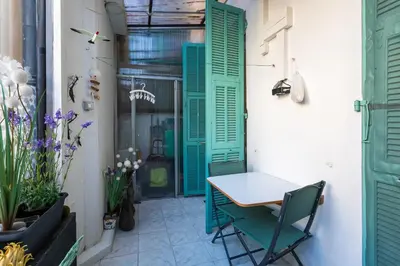 a small patio with green shutters and a table and chairs at PORT CARNOT AP4405 By Riviera Holiday Homes in Nice
