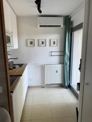 a kitchen with white cabinets and a window and a sink at Art Studio Nice in Nice