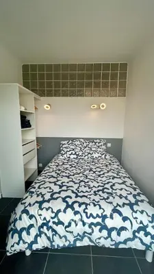a bedroom with a bed with a blue and white comforter at oliveraie in Nice