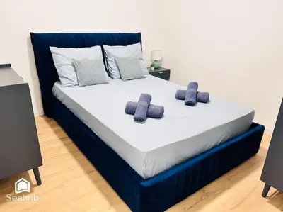 a blue bed with two pillows on top of it at Charming Downtown - AC - WiFi - Private Entrance in Nice