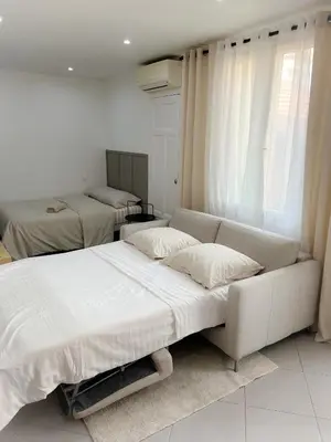 a white bedroom with two beds and a couch at République in Nice