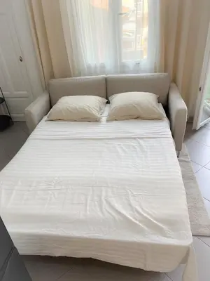 a large white bed with two pillows in a room at République in Nice