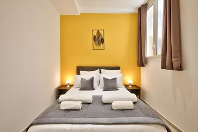 a bedroom with a large bed with yellow walls at Cosy Apparts Hypercentre de Nice in Nice