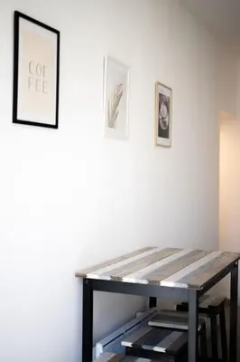 a table in a room with two pictures on the wall at Magnifique 3 pièces de 80m2 dans le Carré d'Or in Nice