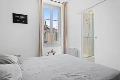 a white bedroom with a bed and a window at Magnifique 3 pièces de 80m2 dans le Carré d'Or in Nice