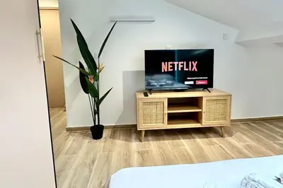 a tv sitting on a stand in a room at Appartement climatisé - 2min plage-tram-restaurant in Nice
