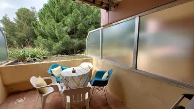 a patio with chairs and a table on a balcony at Studio piscine climatisation tennis in Nice