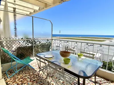 a table and chairs on a balcony with a view of the ocean at Large flat terrace Sea view, Promenade des Anglais in Nice