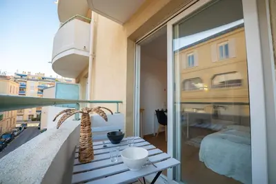 a balcony with a palm tree and a bedroom at Cocon Urbain - Près de la Gare in Nice