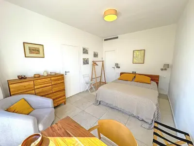 a bedroom with a bed and a couch and a table at Cosy Sea Front Garden Nice in Nice