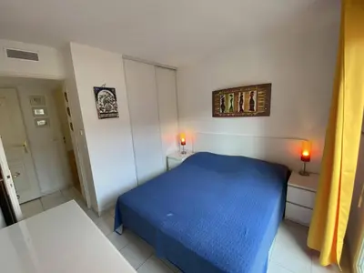 a small bedroom with a blue bed and two lamps at Nice Magnan 2P-Piscine, Clim, Parking in Nice