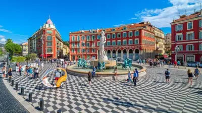 a group of people walking around a fountain in a city at À 2 pas du centre in Nice