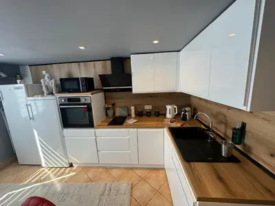 a kitchen with white cabinets and white appliances at Duplex proche port de Nice in Nice