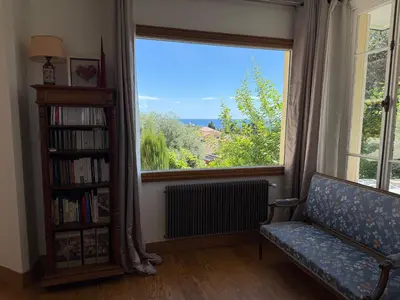 a living room with a couch and a large window at Magnifique villa pieds dans l eau Saint Jean Cap Ferrat in Saint-Jean-Cap-Ferrat