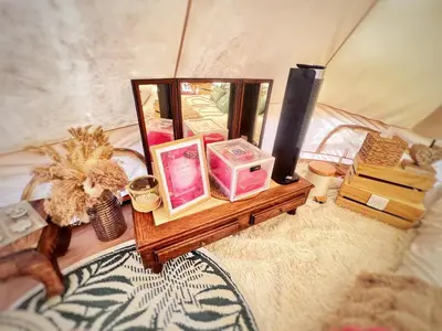 a table with cosmetics and other items on a bed at LOVE ROOM Tente chauffée Lodge spa MFG chez C&C, exclusivement réservée aux ADULTES in Cantaron