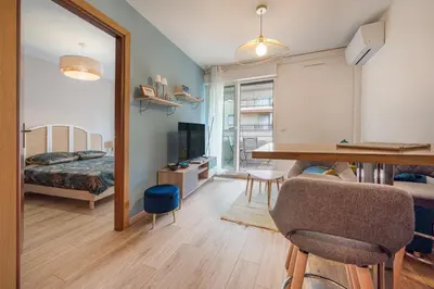 a room with a table and a bed and a mirror at Magnifique 2 pièces, Clim, parking , wifi in Beaulieu-sur-Mer
