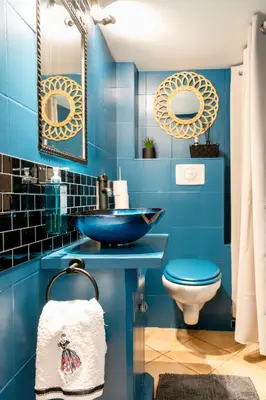 a blue bathroom with a sink and a toilet at Appartement en duplex in Nice