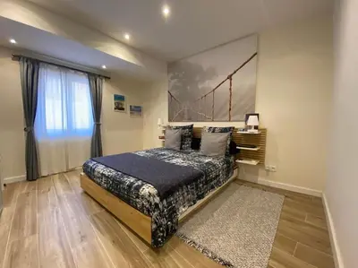 a bedroom with a bed and a large window at 2 pièces Vieux Nice - Deux pas de la mer in Nice