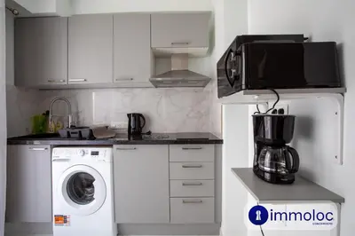 a kitchen with a washing machine and a microwave at Studio Air-conditioned district of the Musicians in Nice