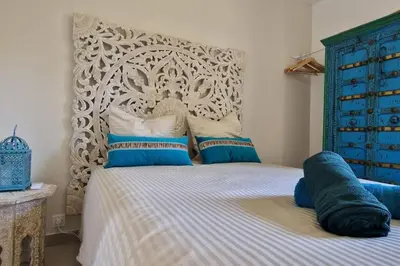 a bedroom with a bed with a blue and white headboard at Rêves d'Orient - proche mer in Nice