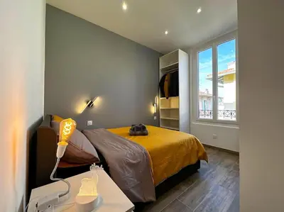 a bedroom with a bed and a large window at Chic Renovated Home - Nice Libération - Entire 2BR 2BA Apartment or Private Rooms with Private Bathrooms - AC and Garage on request in Nice