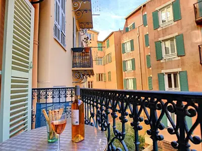 a table with two glasses of wine on a balcony at Nestor&Jeeves - PLACE DU PIN - Near Port - Old town in Nice
