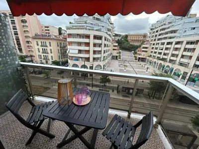 a table and chairs on a balcony with a view of a city at Studio à deux pas de la mer in Nice