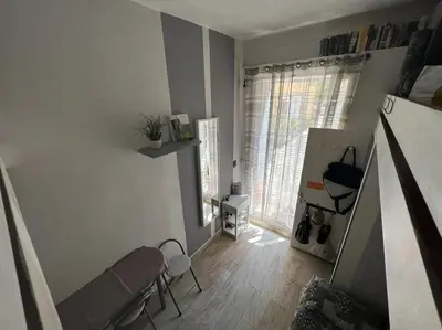 a living room with a couch and chairs and a window at Petit studio de charme in Villefranche-sur-Mer