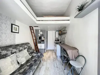 a living room with a couch and a table at Petit studio de charme in Villefranche-sur-Mer