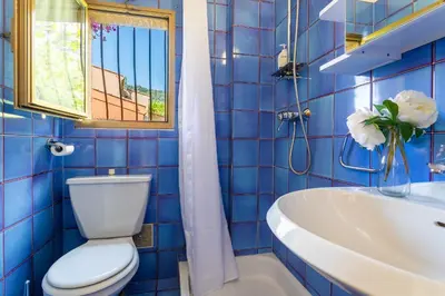 a blue tiled bathroom with a toilet and a sink at VILLA LA PETITE RESERVE VI4416 By Riviera Holiday in Èze