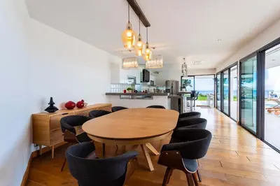 a kitchen and dining room with a wooden table and chairs at VILLA ADRIANA VI4411 By Riviera Holiday Homes in Nice