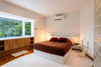 a bedroom with a bed with red pillows and a window at VILLA ADRIANA VI4411 By Riviera Holiday Homes in Nice